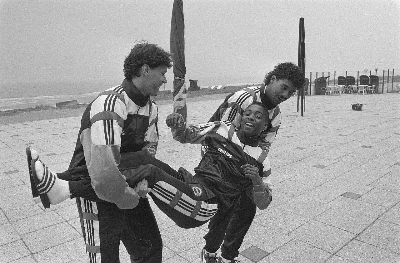 Marco van Basten (left) and Frank Rijkaard hoist a laughing Brian Roy at a Dutch national team gathering in Noordwijk, 21 April 1989 — two days after Sacchi's Milan had swept Real Madrid 5-0 at San Siro to reach the European Cup final. Rijkaard, in his first rossonero season, was weeks from crowning it at Camp Nou.