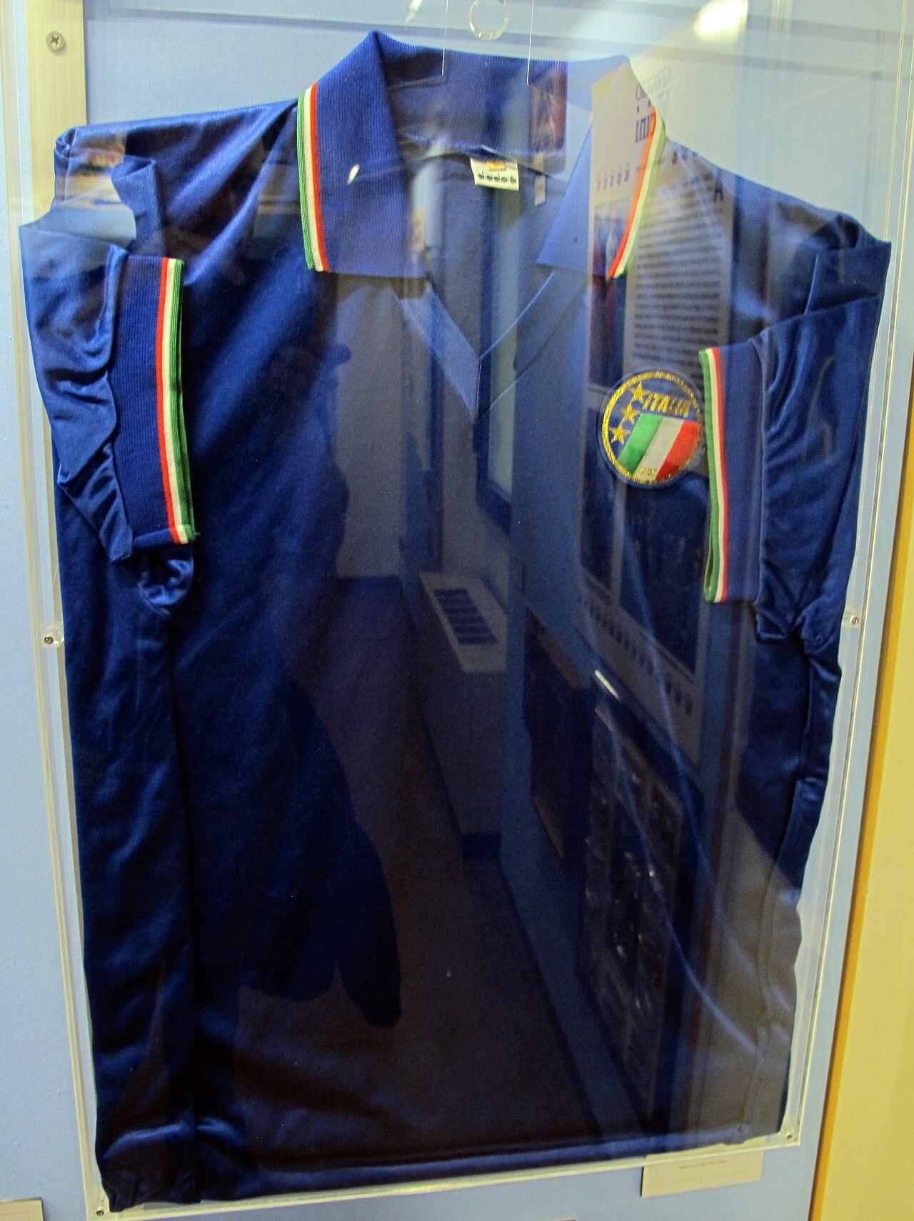 The Diadora azzurri shirt Paolo Maldini wore at Italia '90, preserved at the Museo del Calcio in Florence. At 21, Milan's left-back played every minute of Italy's run to the semi-finals in the summer between the second European Cup and the Intercontinental triumph in Tokyo — the boy of the Sacchi machine becoming a pillar of the nation.