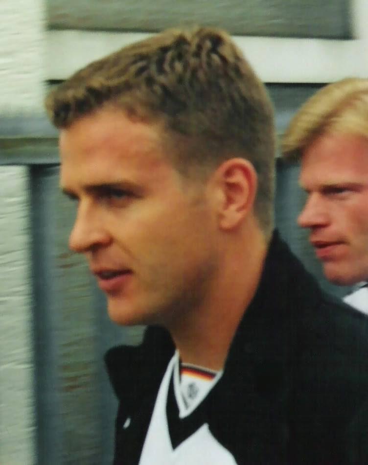Oliver Bierhoff at Germany national-team training near Bonn, circa 1999, Oliver Kahn at his shoulder. The Euro 96 golden-goal hero arrived at Milan from Udinese in the summer of 1998 — a doubted 30-year-old — and answered with a brace against Bologna on opening day, then roughly twenty league goals to drive the centenary scudetto.
