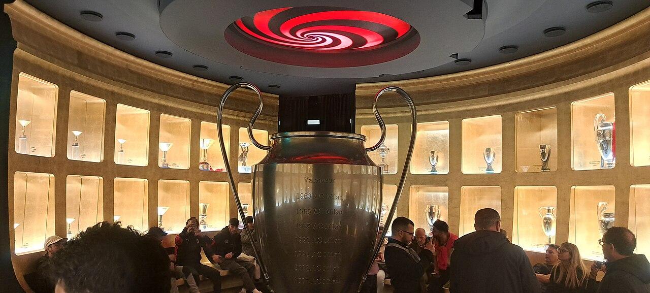 The trophy hall at Casa Milan: an outsized European Cup engraved with the club's winning years, ringed by lit niches holding a century of silver. This was the inheritance Milan carried into its centenary — and in May 1999 the sixteenth Italian title was added to it, the first since 1996 and the answer to three seasons of humiliation.