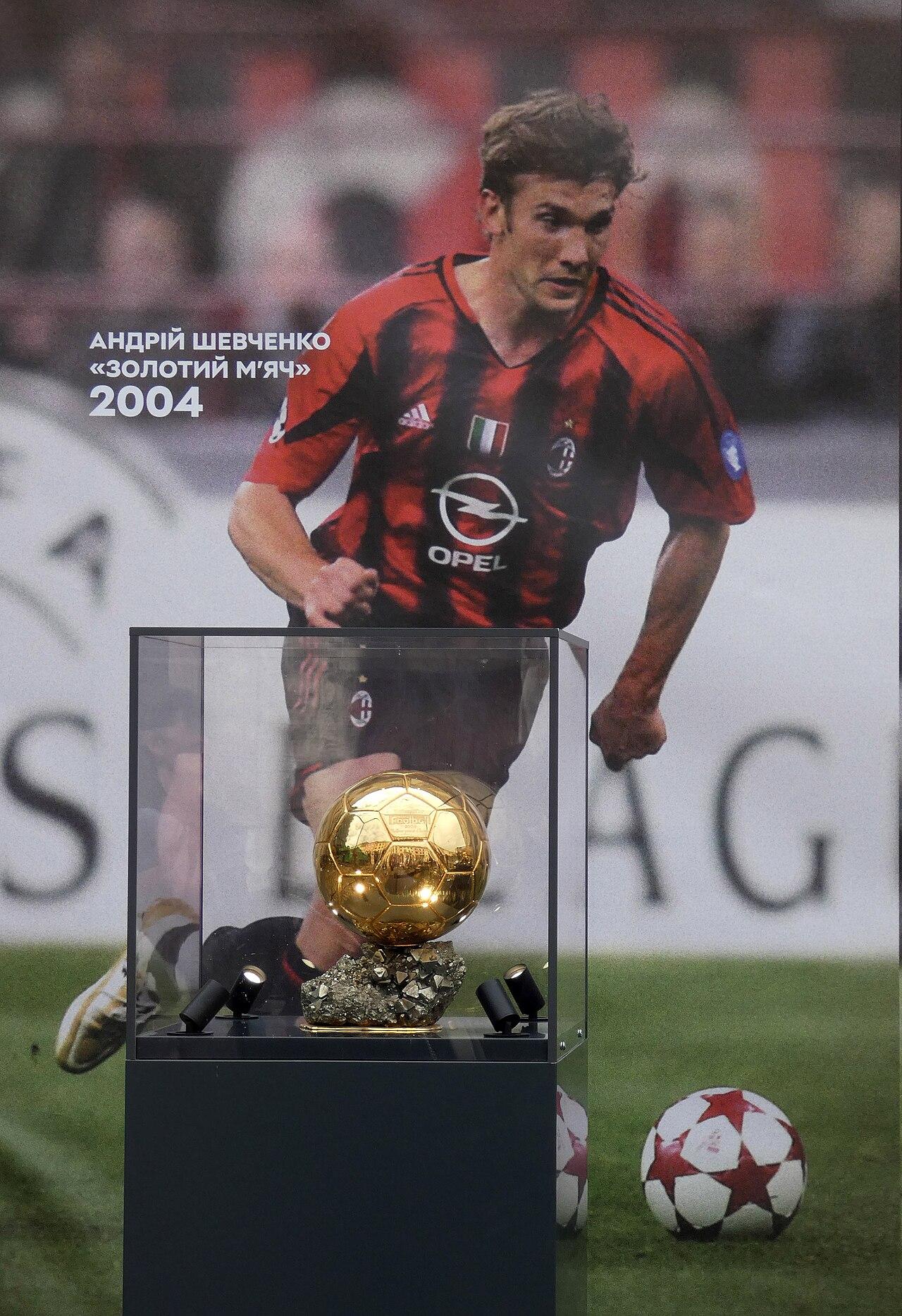 The 2004 Ballon d'Or itself — Shevchenko's, the last ever won by a Milan player — displayed against a portrait of him in the rossonero of the scudetto season.