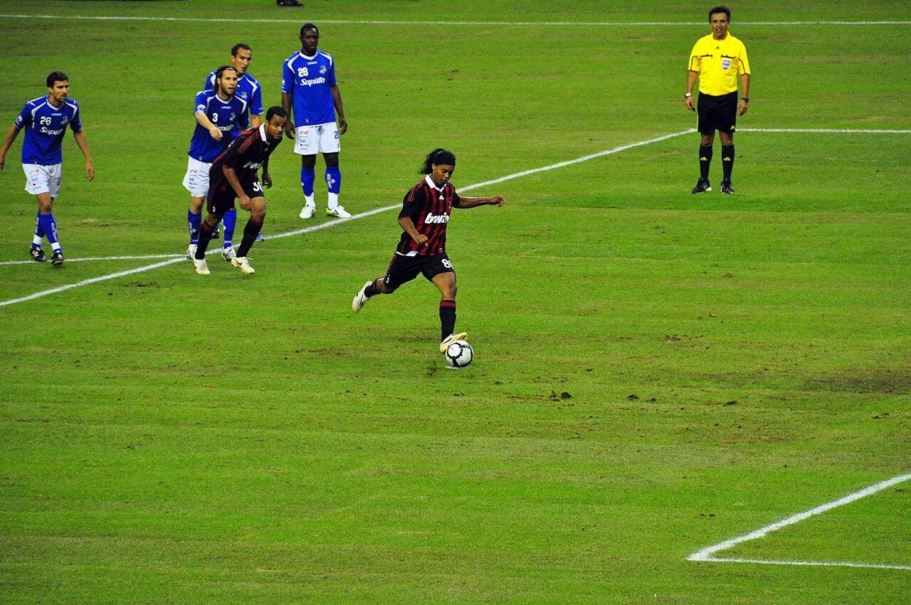 Ronaldinho striking a penalty in the Milan shirt on the club's post-season tour, 2 June 2010 — the Brazilian rediscovered in 2009-10 as the side rebuilt around him after Kaká's departure.