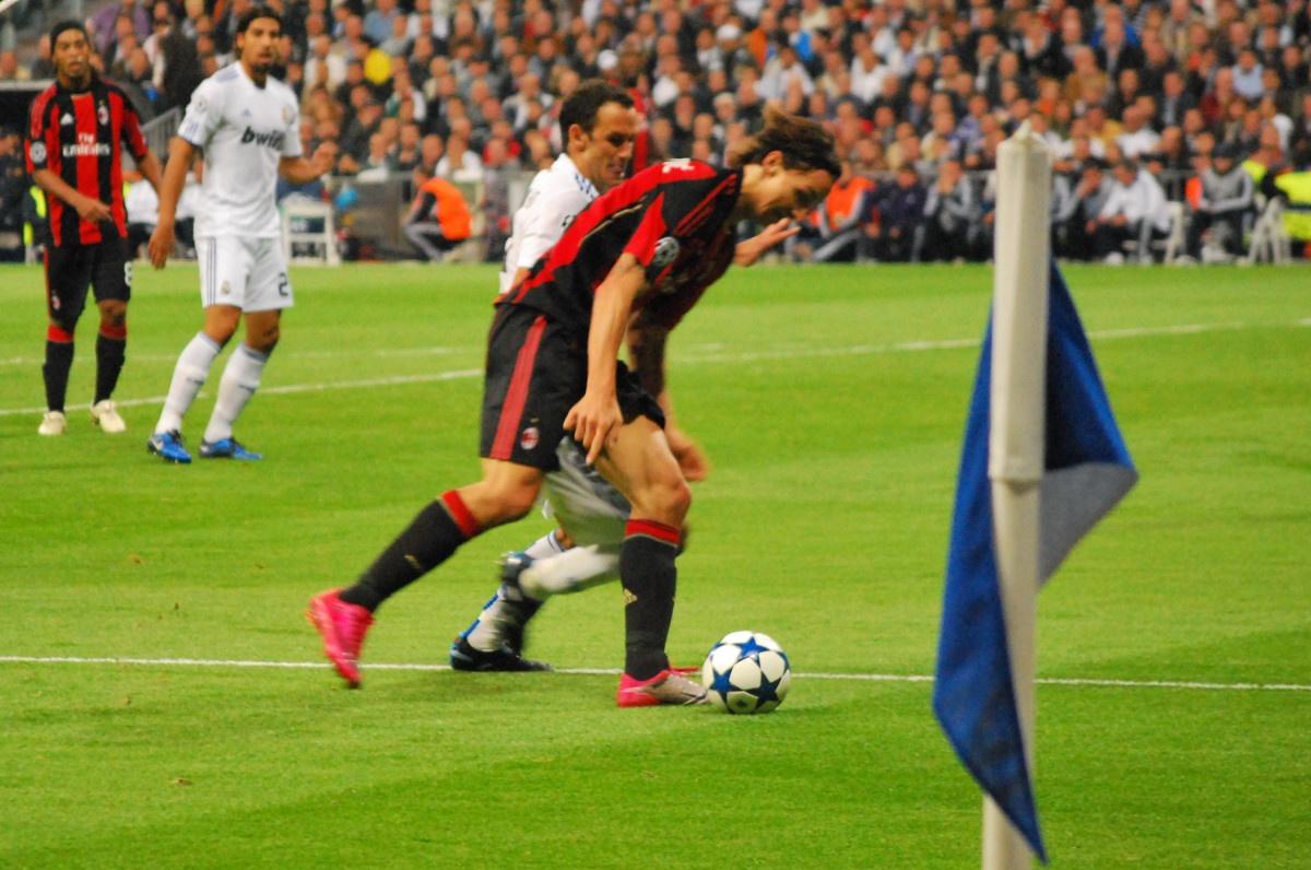 Zlatan Ibrahimović shields the ball by the corner flag against Ricardo Carvalho at the Santiago Bernabéu — Real Madrid v Milan, Champions League group stage, autumn 2010, with Ronaldinho watching from the left. Signed on loan from Barcelona that August, the Swede finished 2010-11 as Milan's top scorer with 21 goals.