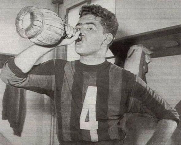Carletto Annovazzi, the young mediano in the number 4 rossonero shirt, drinks from a fiasco in the dressing room after Juventus 1-2 Milan, 2 March 1947 — the season Milan's post-war rebuild found its legs.