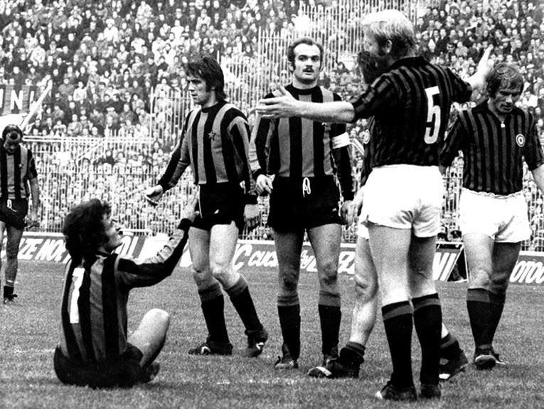 San Siro, 19 November 1972: the derby ends Milan 3-2 Inter on matchday 7 of the 1972-73 Serie A — Karl-Heinz Schnellinger (No. 5) in the thick of it, the Coppa Italia coccarda on the rossonero shirts.