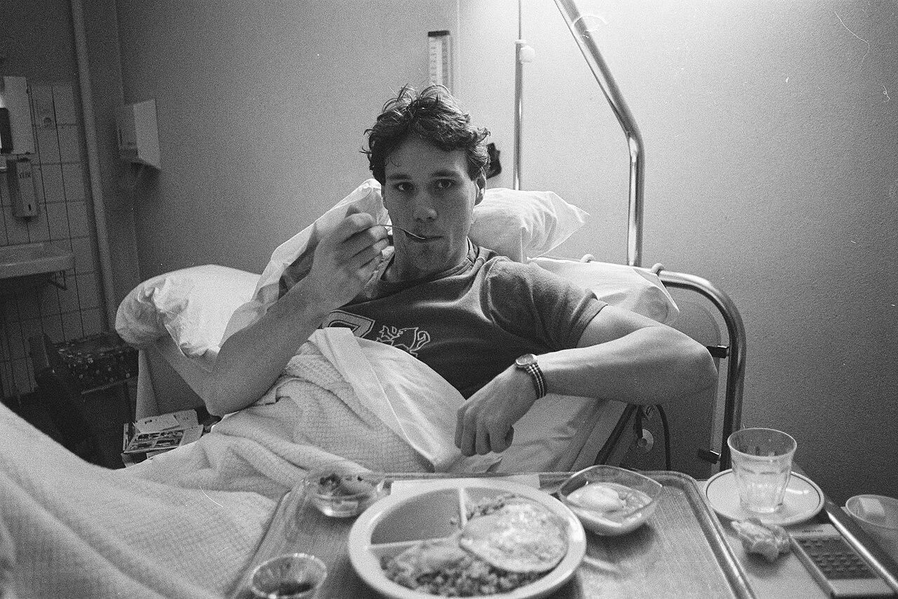 Marco van Basten, Ajax's top scorer, eats his hospital dinner on 16 December 1986 while awaiting surgery on the ankle that would shadow his whole career. Ten months after Berlusconi seized Milan, the new regime was already circling Europe's deadliest young striker — troublesome ankle and all.